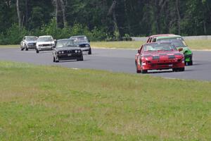 A stream of cars comes out of turn 3 into turn 4