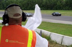 The white flag comes out at turn 2 as Wells Mafia Ford Mustang and Chump Faces BMW 325is pass by.