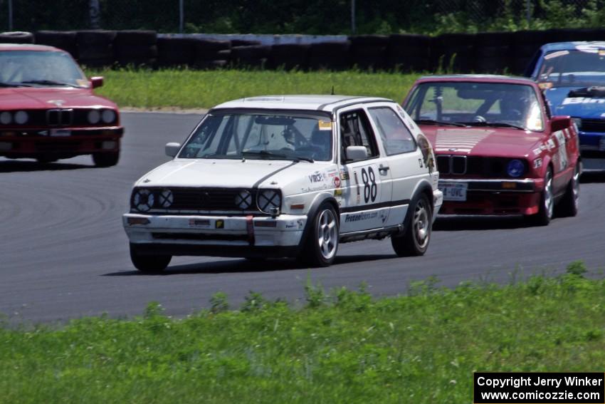 JAB Motorsport VW GTI and Missing Link Motorsport BMW 325 lead a pack through the carousel