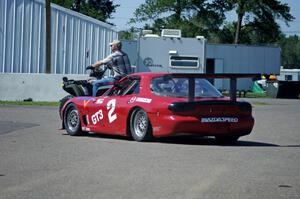 Doug Sherwood's GT-3 Mazda RX-7 gets pulled through the paddock