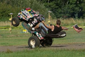 An animal in the infield of BIR rides a wheelie on his riding lawnmower.