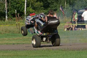 An animal in the infield of BIR rides a wheelie on his riding lawnmower.