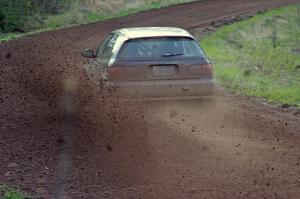 Silas Himes / Matt Himes spray gravel on a sweeper on stage four in their Honda Civic.