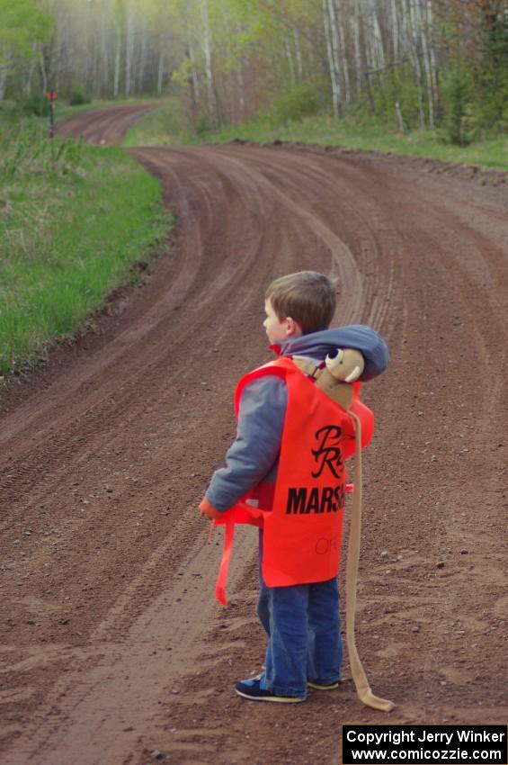 A young marshal awaits the start of stage four.