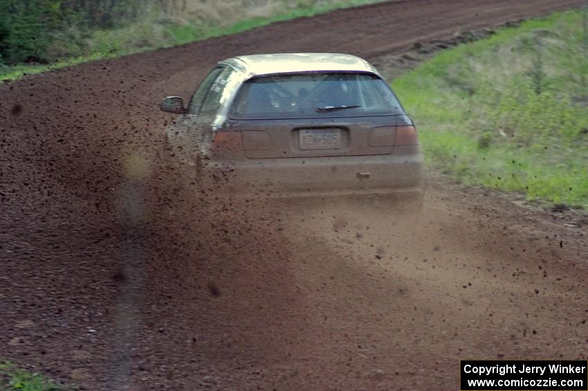 Silas Himes / Matt Himes spray gravel on a sweeper on stage four in their Honda Civic.