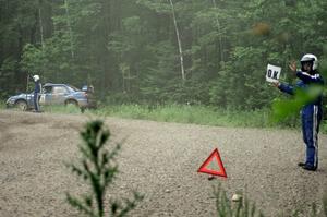 Dave Goodman displays the 'OK' sign while Carl Siegler waits to get his Subaru WRX STi freed from the berm.