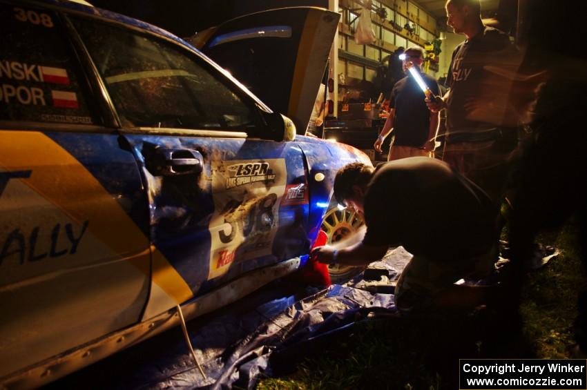 Work is performed on the Janusz Topor / Michal Kaminski Subaru WRX STi at Friday's service.