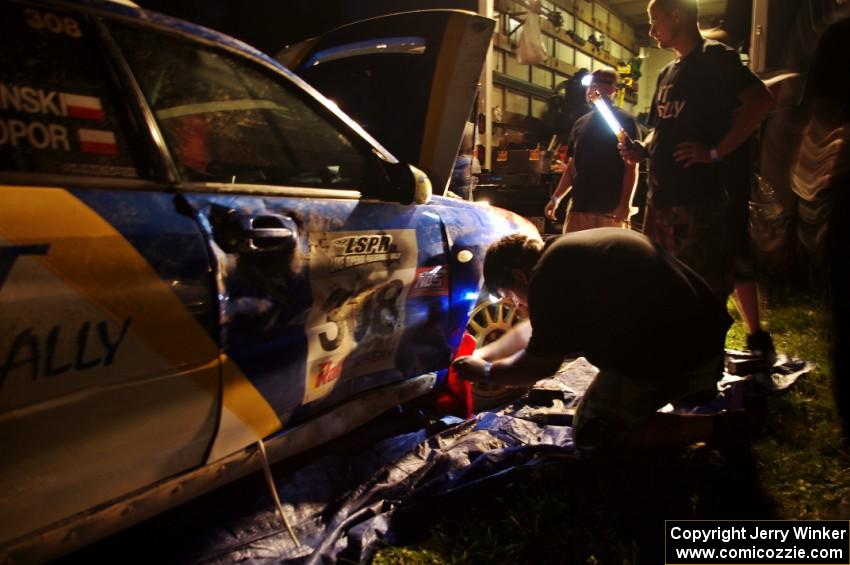 Work is performed on the Janusz Topor / Michal Kaminski Subaru WRX STi at Friday's service.