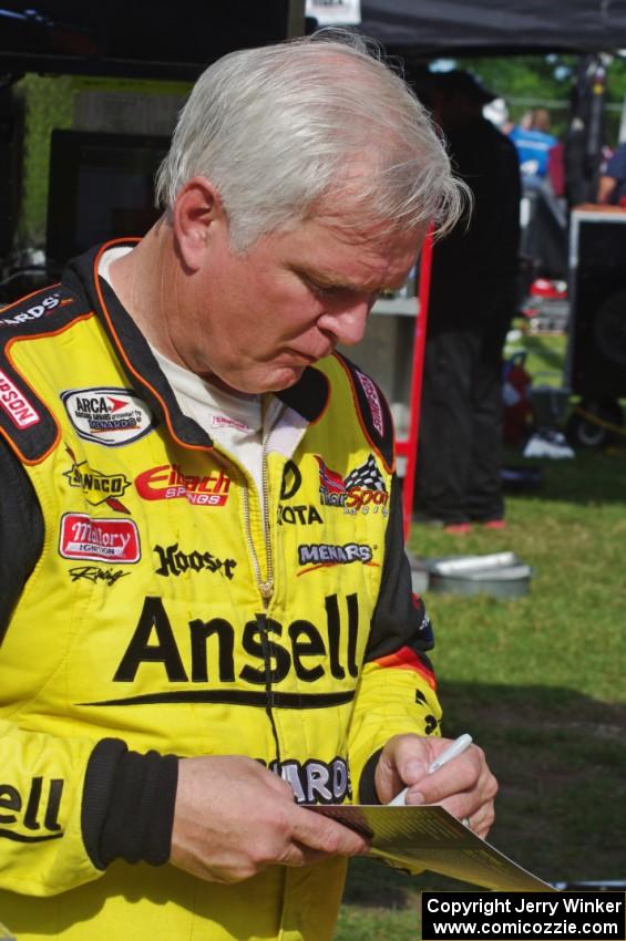 Frank Kimmel signs an autograph in the paddock.