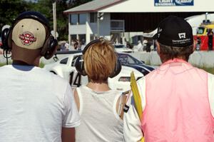 Corner captain Bob Brist and two others watch Joe Ebben's Ford Mustang go past at turn 12