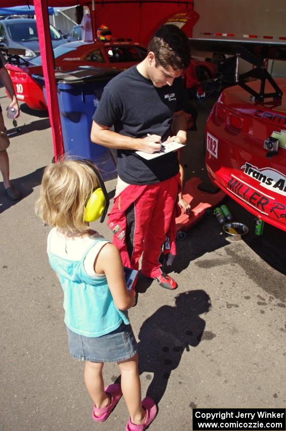 Cameron Lawrence signs an autograph for a young fan.