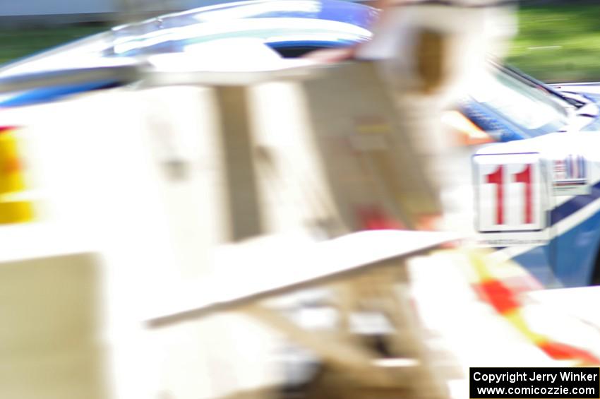 Jim Norman's Porsche GT3 Cup goes past corner workers at the bridge