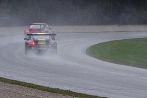 John Baker's and Porsche GT3 Cup cars in the carousel in the pouring rain