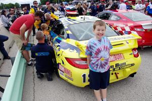A young fan poses in front of the Nick Longhi / Matt Plumb Porsche 997
