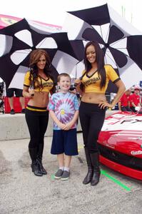 Grid girls pose with a young fan