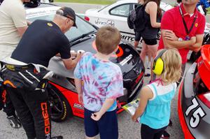 Ray Mason signs an autograph for a couple of fans