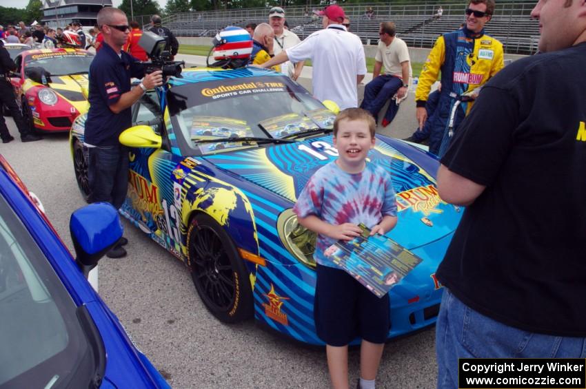 A young fan poses in front of the Nick Longhi / Matt Plumb Porsche 997