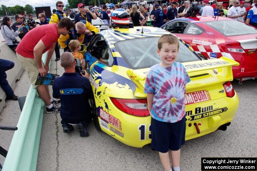 A young fan poses in front of the Nick Longhi / Matt Plumb Porsche 997