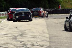 Ian James / Roger Miller Ford Mustang Boss 302R GT trails a pack of GS cars into turn 7