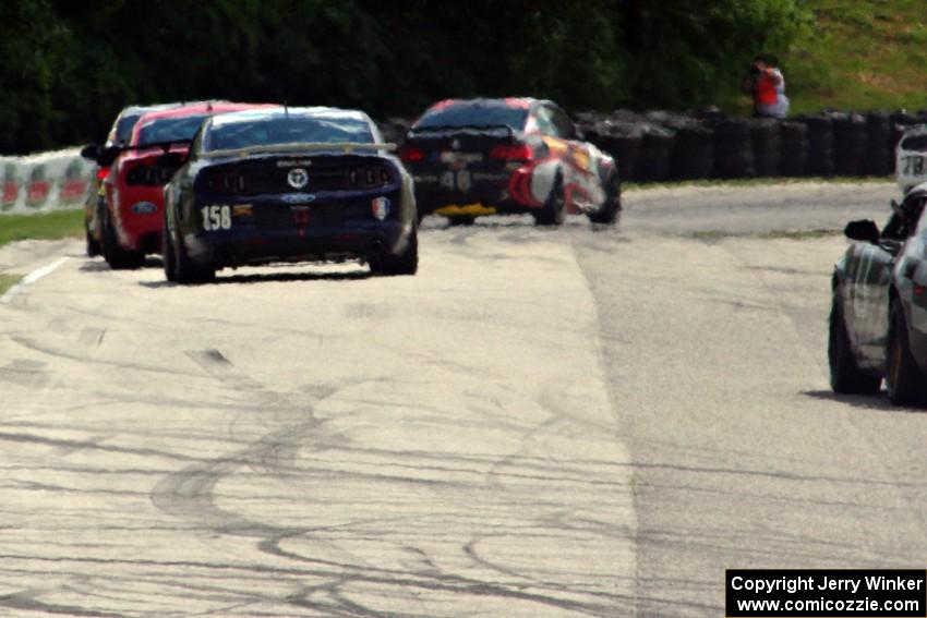 Ian James / Roger Miller Ford Mustang Boss 302R GT trails a pack of GS cars into turn 7