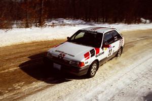 Mark Cox / Jim Gill at speed on SS5, Avery Lake I, in their Mazda 323GTX.