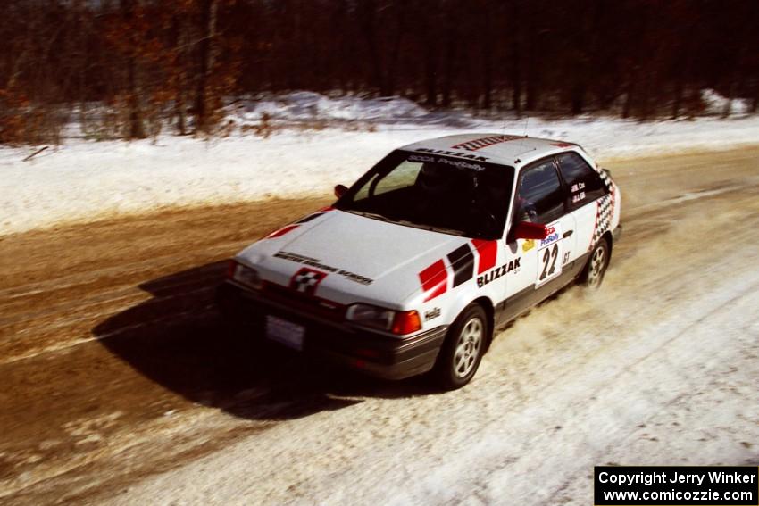 Mark Cox / Jim Gill at speed on SS5, Avery Lake I, in their Mazda 323GTX.