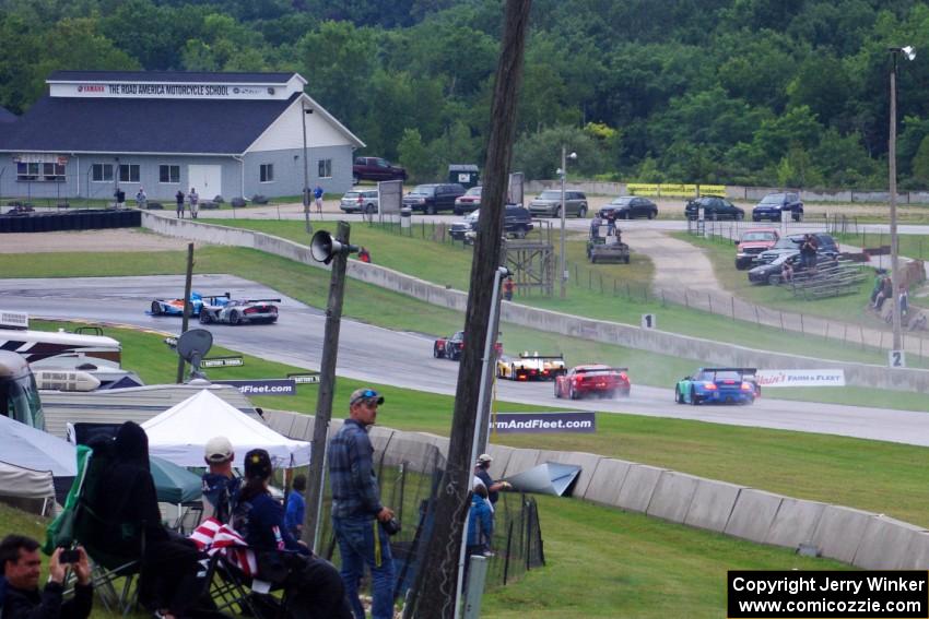 A large group of PC and GT cars dive into turn 8 on the first lap