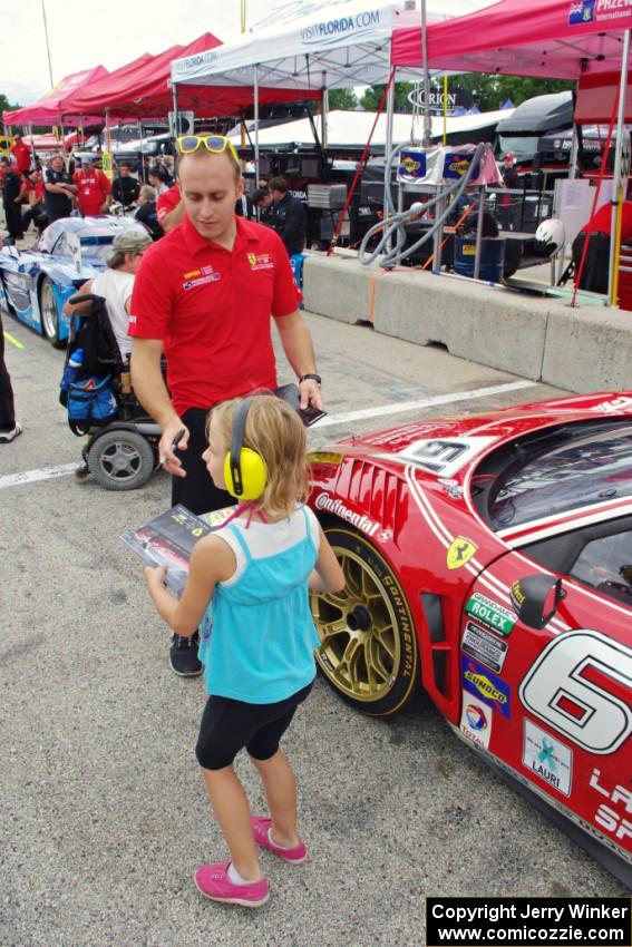 Jeff Segal signs an autograph for a fan in front of his Ferrari 458 Italia