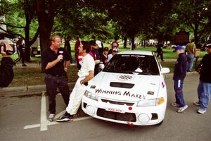 Érik Comas is interviewed by Doug Plumer in front of the Mitsubishi Lancer Evo IV he and Julian Masters shared.
