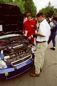 Jeff Burmeister interviews Bryan Hourt and Tom Tighe in front of their Honda Civic.