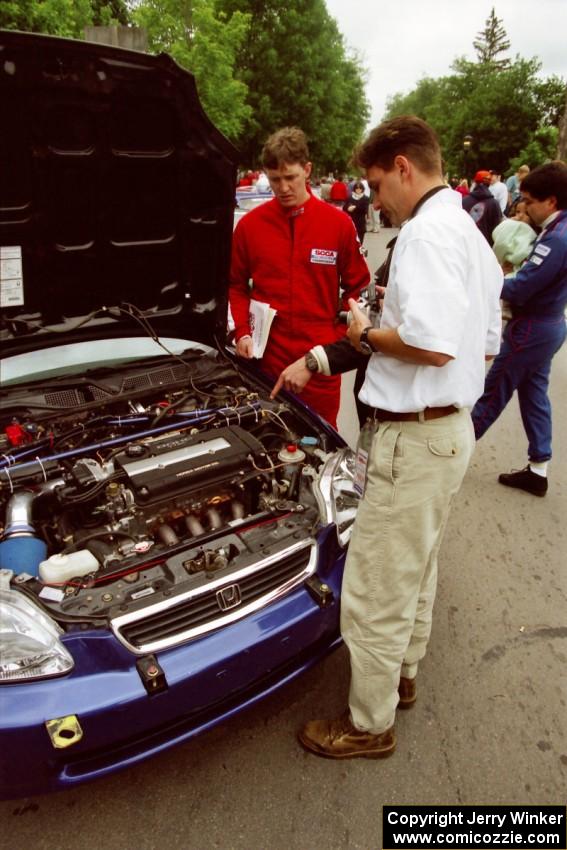 Jeff Burmeister interviews Bryan Hourt and Tom Tighe in front of their Honda Civic.