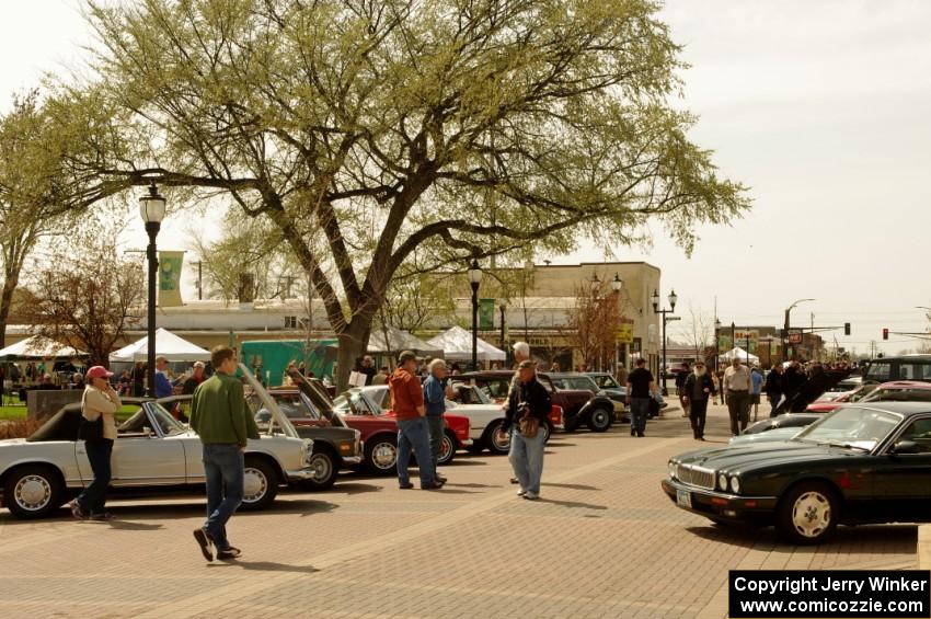 Various Mecedes-Benzs and Jaguars in front of the town square of Osseo