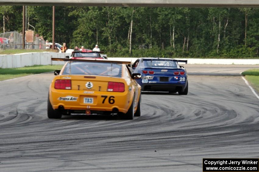 Chuck Cassaro's Ford Mustang chases down Fernando Seferlis' Chevy Camaro