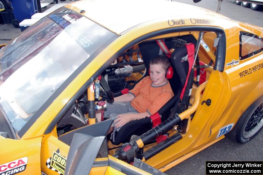 A young fan seated in Chuck Cassaro's Ford Mustang.