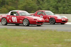 Dan Schaut's STL Mazda Miata gets the inside line on Jamey Randall's Spec Miata Mazda Miata.