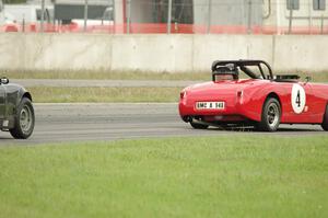 Tom Daly's Austin-Healey Sprite leads Phil Schaefer's Austin-Healey Sprite through the carousel.