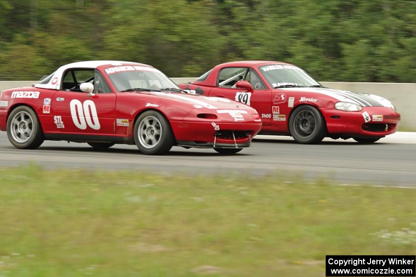 Dan Schaut's STL Mazda Miata gets the inside line on Jamey Randall's Spec Miata Mazda Miata.