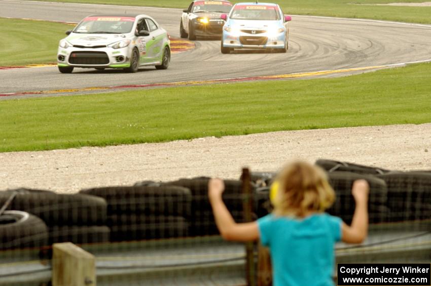 Jason Wolfe's Kia Forte Koup, Shea Holbrook's Honda Civic Si and Jason Cherry's Mazda MX-5 on the final lap.