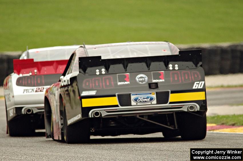 Chris Buescher's Ford Mustang chases Alex Tagliani's Dodge Challenger