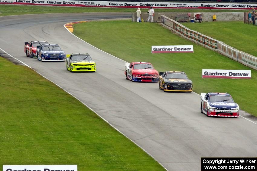 Trevor Bayne's Ford Mustang leads five other cars into turn 7.