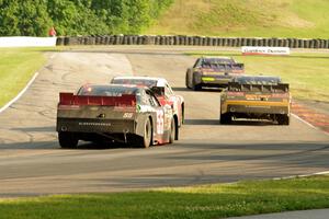 Chase Elliott's, Brendan Gaughan's, Kevin O'Connell's and Andy Lally's Chevy Camaros battle at turn 6 with just over a lap to go