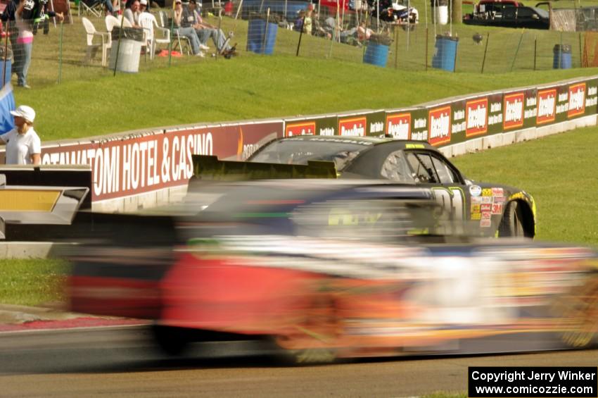 Justin Marks' Chevy Camaro stops at turn 6 as Kenny Habul's Toyota Camry passes by.