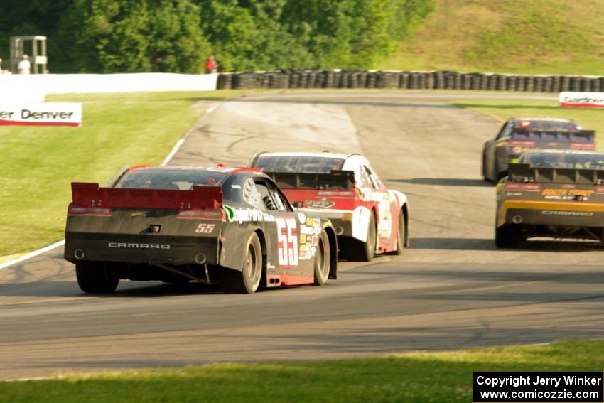 Chase Elliott's, Brendan Gaughan's, Kevin O'Connell's and Andy Lally's Chevy Camaros battle at turn 6 with just over a lap to go