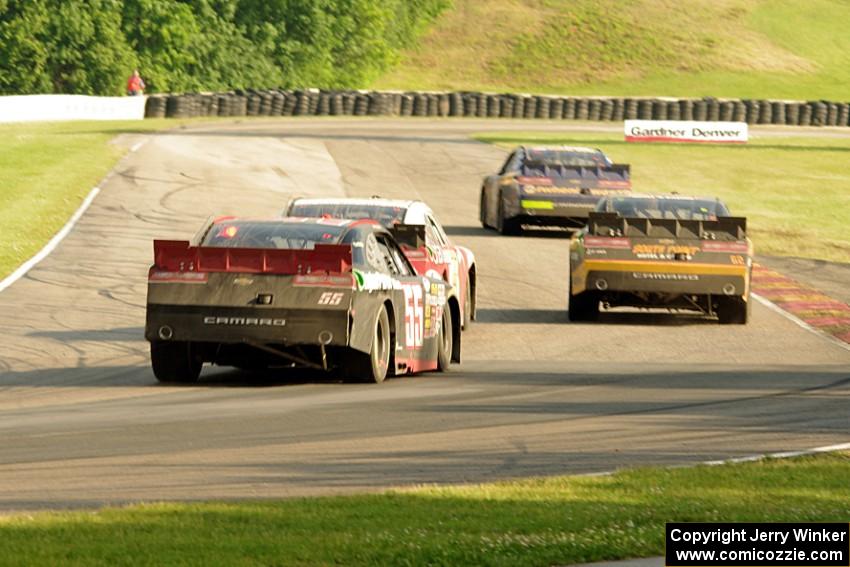 Chase Elliott's, Brendan Gaughan's, Kevin O'Connell's and Andy Lally's Chevy Camaros battle at turn 6 with just over a lap to go