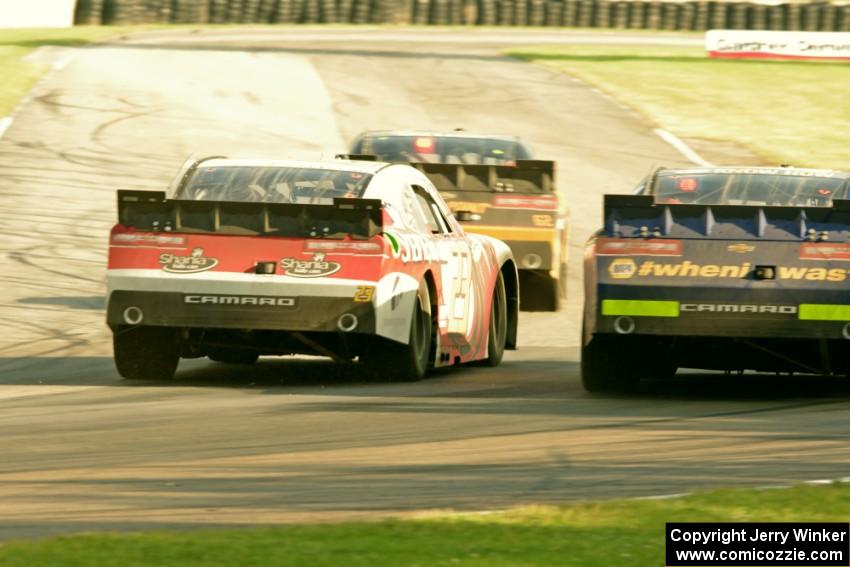 Brendan Gaughan's, Kevin O'Connell's and Chase Elliott's Chevy Camaros battle at turn 6 on the final lap.