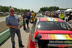 Yurek Cienkosz poses next to the Ray Mason / Pierre Kleinubing Subaru WRX STi on the grid walk.