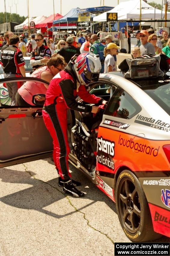 James Vance and Katherine Legge practice pits stops in their Honda Civic during the grid walk.