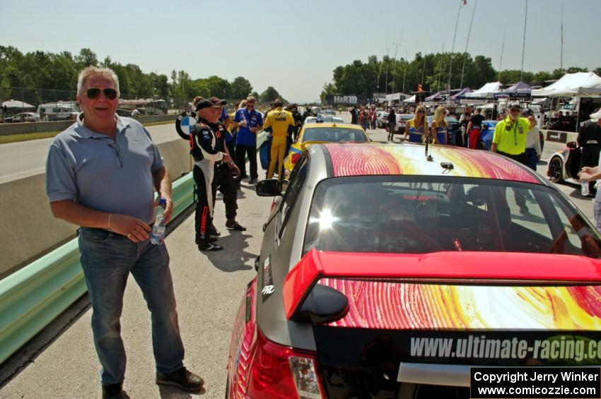 Yurek Cienkosz poses next to the Ray Mason / Pierre Kleinubing Subaru WRX STi on the grid walk.