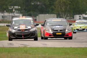 Chris Holter's Mazda 2 is passed by Ray Mason's Honda Civic Si