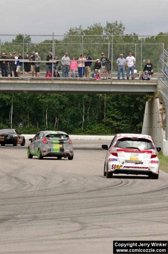 Brian Price's Honda Fit chases Ernie Francis, Jr.'s Mazda MX-5 and Nate Stacy's Ford Fiesta